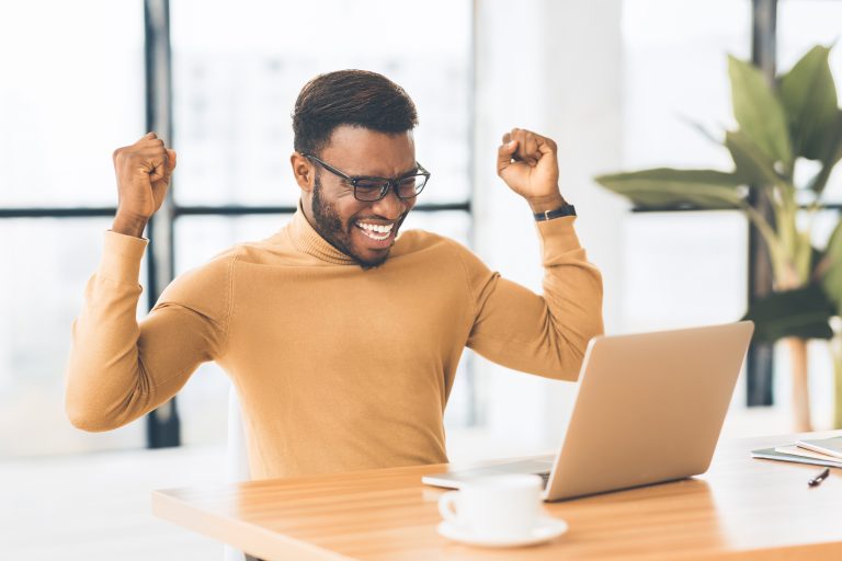 Homme content devant son ordinateur